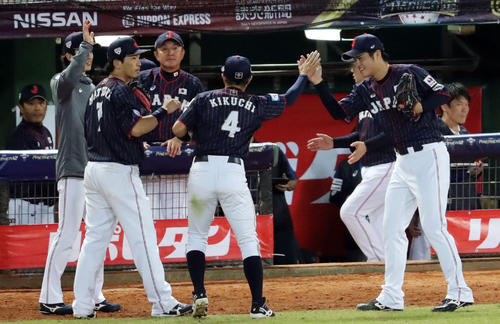 日本対台湾　7回裏台湾の攻撃を無失点に抑えた甲斐野（右）は菊池（中央）らナインを笑顔で出迎える（撮影・垰建太）