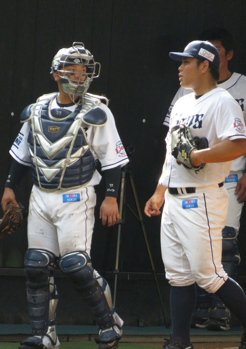 ブルペン投球を終え、西武森（左）と話す平良（撮影・栗田成芳）