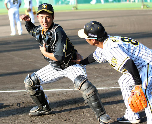 阪神片山（左）はサブグラウンドで藤井彰人バッテリーコーチの指導を受ける（撮影・上山淳一）