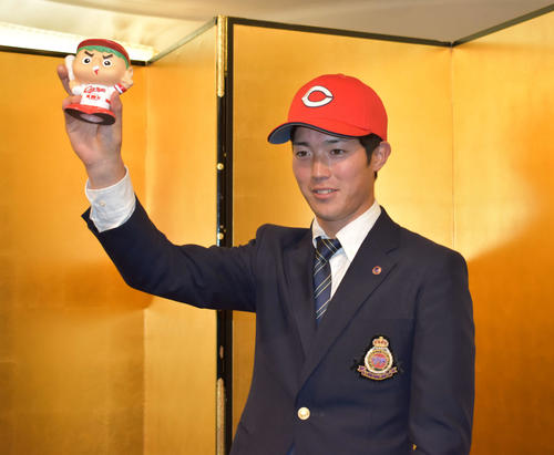 広島と仮契約を結び、カープ坊やのマスコットを右手に写真に納まるドラフト1位の森下（撮影・古財稜明）