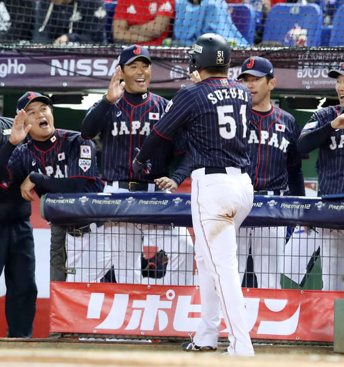 日本対台湾　1回表日本2死三塁、鈴木は吉田正の右前適時打で生還し稲葉監督（左）とタッチする（撮影・加藤哉）