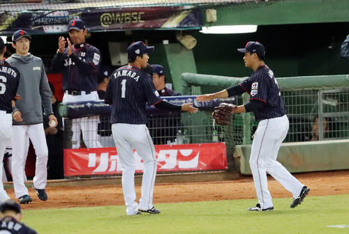 日本対台湾　3回裏台湾2死満塁、朱を三振に仕留め引き揚げる今永（右）は山田とタッチを交わす。左は拍手する稲葉監督（撮影・垰建太）