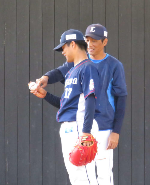 ブルペンで西武松本航（左）にスライダーの握りを伝授する西口投手コーチ（19年11月7日）