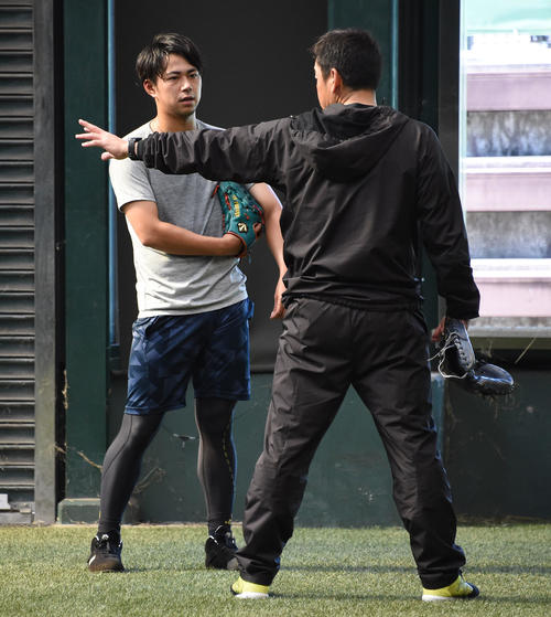休日、古谷優人をブルペンで指導する倉野信次ファーム投手統括コーチ（撮影・今浪浩三）