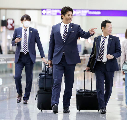 関係者と談笑しながら搭乗口へ向かう稲葉監督（撮影・加藤哉）