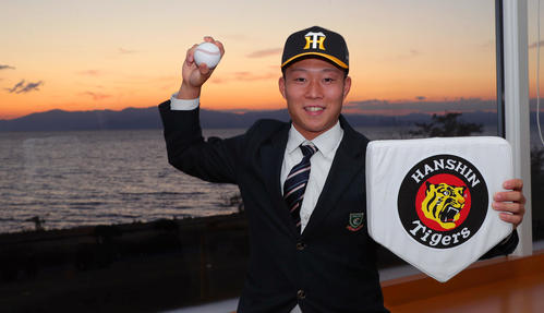 阪神と仮契約を結んだ藤田は慣れ親しんだ琵琶湖・長浜の夕景をバックに決意を示す（撮影・宮崎幸一）