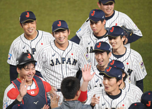 日本対オーストラリア　オーストラリアに勝利してベンチで秋山（下）の出迎えを受け、笑顔を見せる鈴木（中央左）、周東（同右）ら侍ジャパンナイン（撮影・加藤諒）