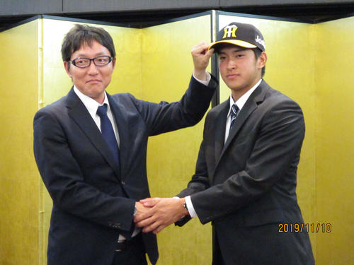 阪神と仮契約を結び、吉野担当スカウトと握手を交わす阪神育成2位奥山（撮影・只松憲）