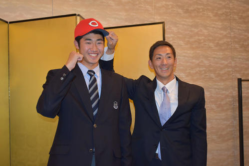 ガッツポーズを見せるドラフト3位・鈴木寛（左）と尾形スカウト