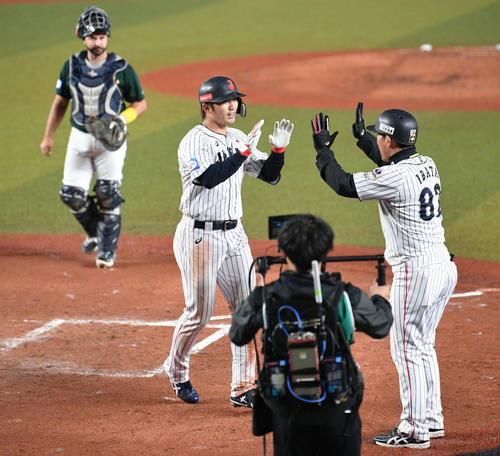 日本対オーストラリア　4回裏日本2死、左越えソロ本塁打を放って生還した鈴木（左から2人目）は井端コーチとタッチを交わす（撮影・滝沢徹郎）