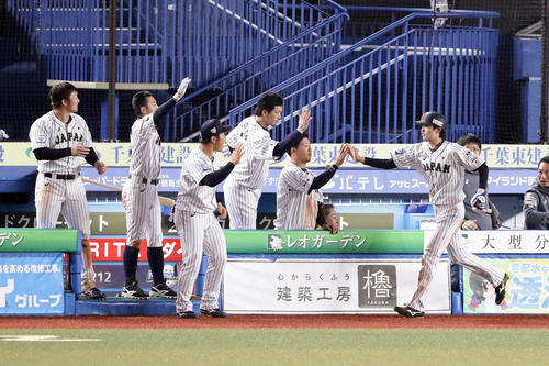 日本対オーストラリア　7回裏日本2死三塁、源田のセーフティーバントで同点の生還をした周東（右）を笑顔で迎える日本ナイン（撮影・浅見桂子）