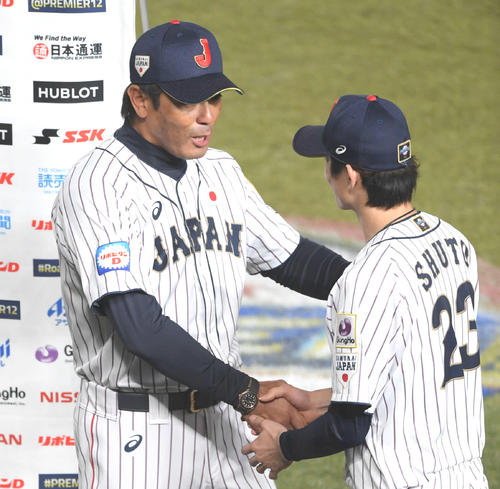日本対オーストラリア　オーストラリアに勝利し、侍ジャパンの稲葉監督（左）に握手で祝福される周東（撮影・加藤諒）