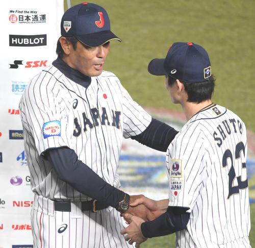 オーストラリアに勝利し、侍ジャパンの稲葉監督（左）に握手で祝福される周東（撮影・加藤諒）