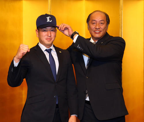 西武との仮契約を終え、渡辺GM（右）に帽子をかぶせてもらう東芝・宮川（撮影・大野祥一）