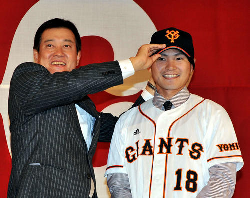 11年12月、巨人入団会見で、杉内（右）は原監督にユニホームを着させてもらい、笑顔を見せた
