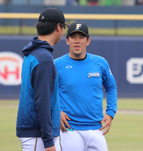 練習中に石川直（左）と会話をする日本ハム西村（撮影・山崎純一）