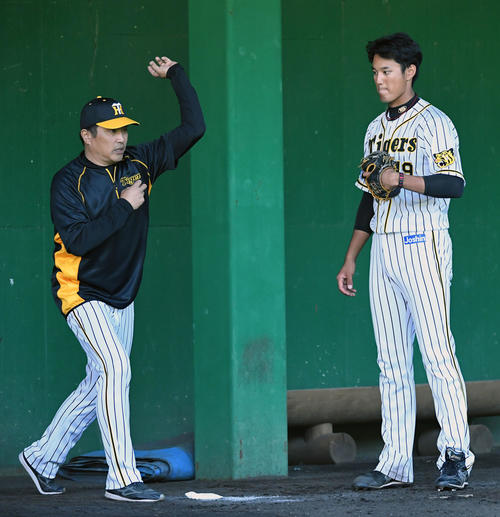 2度目のブルペンで山本昌臨時コーチ（左）のアドバイスを聞く藤浪（撮影・前岡正明）
