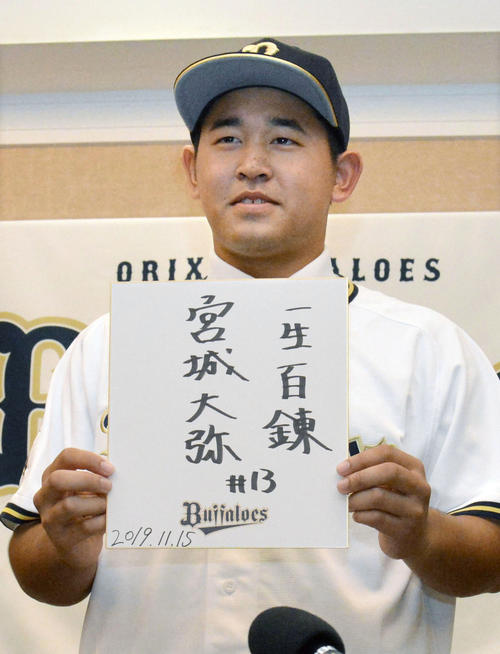 オリックスへの入団が決まり、「一生百錬」と記した色紙を掲げる興南・宮城（共同）