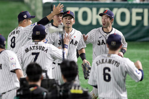 日本対韓国　5回表韓国1死満塁、姜白虎の右飛で三塁走者李政厚のタッチアップ生還阻止を併殺に仕留め、笑顔でナインとハイタッチする鈴木誠也（中央）（撮影・浅見桂子）
