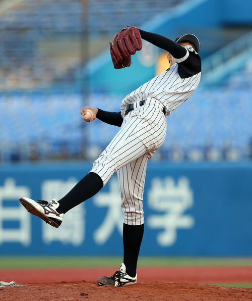 九産大対金沢学院大　背面に体を倒す独特なフォームで投球する九産大・谷口（撮影・大野祥一）