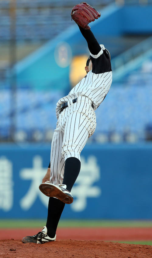 九産大対金沢学院大　背面に体を倒す独特なフォームで投球する九産大・谷口（撮影・大野祥一）
