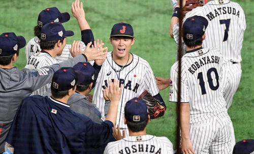 日本対韓国　8回表を投げ終えた山本（中央）は笑顔でナインとタッチを交わす（撮影・滝沢徹郎）