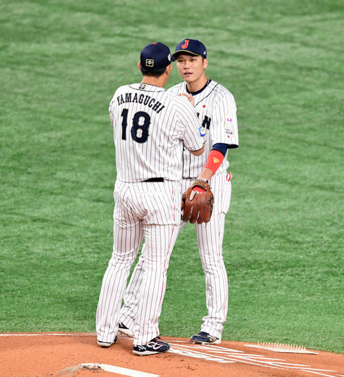 日本対韓国　1回、先頭打者に四球を許した山口（手前）に話しかける坂本勇（撮影・滝沢徹郎）