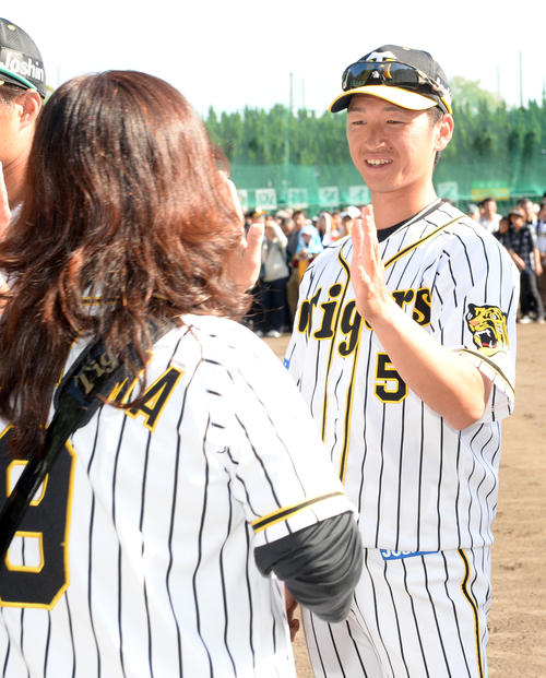 ファンと笑顔でタッチする近本（撮影・前岡正明）