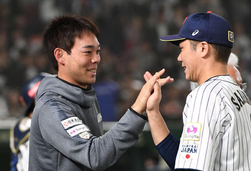 2019年11月16日、日本対韓国　タッチをかわして勝利を喜ぶ秋山（左）と坂本勇（撮影・山崎安昭）