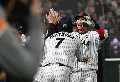 日本対韓国　2回裏日本2死一、二塁、3点本塁打を放った山田哲（右）はチームメートとタッチをかわす（撮影・山崎安昭）