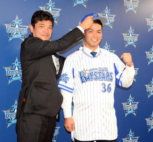 オリックス戦力外から古巣DeNAへ復帰した高城（右）は三原代表から帽子をかぶせてもらいガッツポーズ（撮影・鈴木正章）