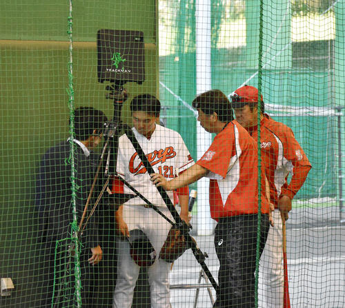 ブルペンでトラックマンの計測データを確認する佐々岡監督（右端）と藤井黎（左から2人目）