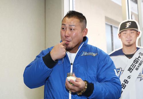 応援大使で訪れた上砂川町役場で地元で生産しているハチミツをなめる日本ハム中田（撮影・黒川智章）