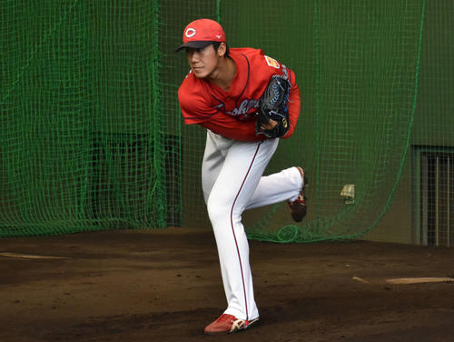 ブルペンで投球練習を行う山口