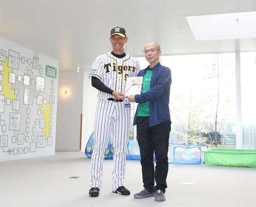 神戸市内の病院で寄付金贈呈式を行う阪神原口。右は院長の楠木重範さん（撮影・前田充）