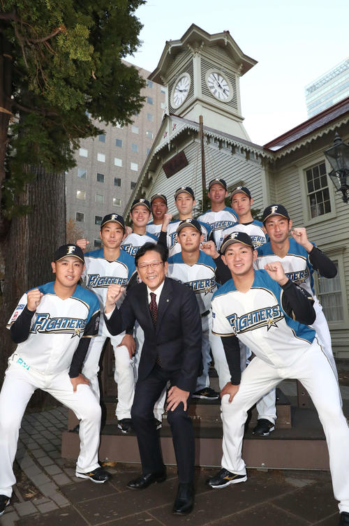 日本ハムの新入団選手発表会見で札幌市時計台を背に意気込む前列左から河野、栗山監督、立野、2列目左から上野、鈴木、望月、3列目左から梅林、片岡、宮田、4列目左から樋口、長谷川（撮影・黒川智章）