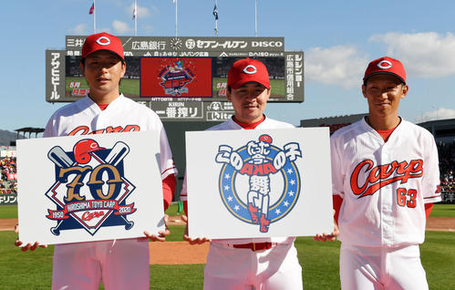 球団創立70周年記念ロゴを披露する大瀬良（左）と2020年のキャッチフレーズを披露する会沢（中央）。右は西川（撮影・前岡正明）