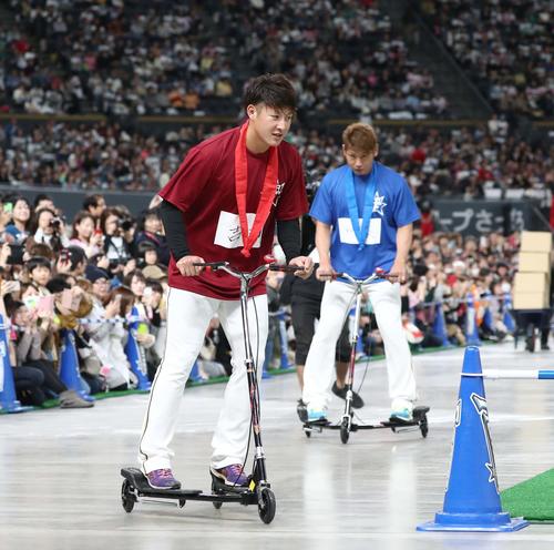 日本ハムファンフェスティバル　リレー対決で乗り物にのる吉田輝。右は加藤（撮影・黒川智章）