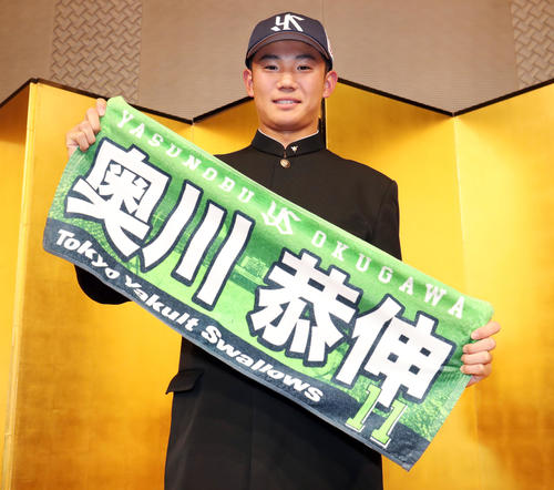 ヤクルトとの仮契約を終えて自身の名前と背番号の入った応援タオルを手に写真に納まるドラフト1位奥川（撮影・垰建太）