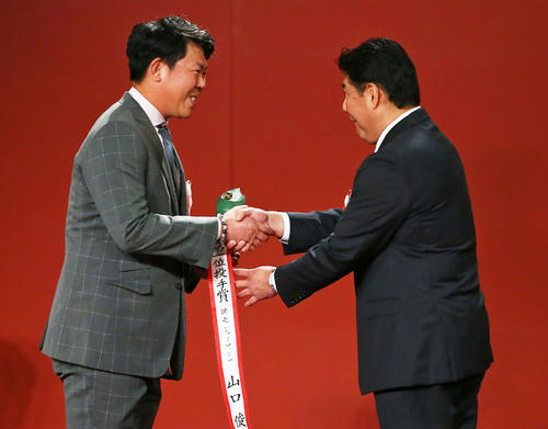 投手部門で3冠を達成した巨人山口（左）はプレゼンターの斎藤氏と笑顔で握手を交わす（撮影・足立雅史）