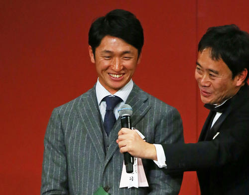  最多盗塁者賞を受賞し壇上で笑顔を見せる阪神近本（撮影・足立雅史）
