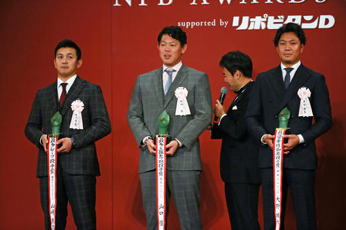 投手部門で3冠を達成した巨人山口（中央）は壇上で笑顔。左は最多セーブ投手賞のDeNA山崎、右は最優秀防御率投手賞の中日大野（撮影・足立雅史）