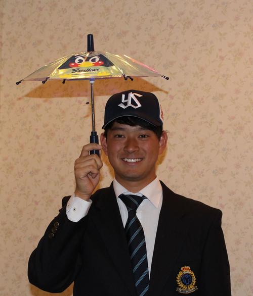 傘を持って笑顔のヤクルトドラフト2位の日体大・吉田（撮影・保坂恭子）
