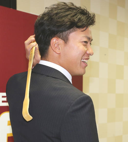 契約更改を終えた楽天渡辺佳は、「かゆい所に手が届くような選手」とばかりに、自らの限定グッズ「孫の手」を手に笑顔（撮影・野上伸悟）