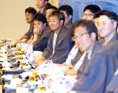 選手会納会で、乾杯のあいさつを聞きながら笑顔を見せる森（中央）（撮影・浅見桂子）