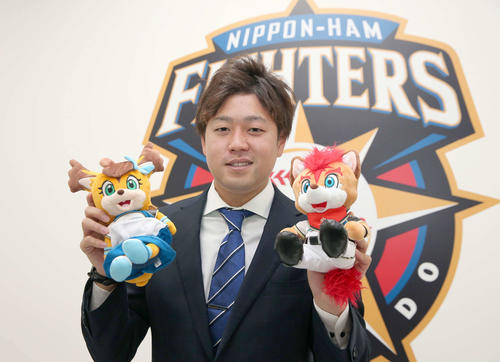 1000万円アップで契約更改を終え球団マスコットを持ち笑顔の日本ハム堀（撮影・黒川智章）