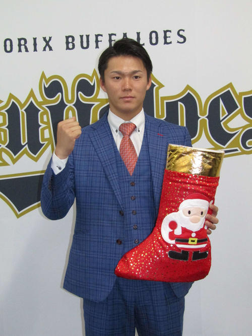 オリックス山本は大幅アップを勝ち取り、サンタクロースの長靴を手にガッツポーズ（撮影・高垣誠）