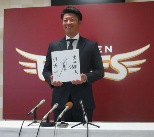 契約更改交渉後の会見で「日本一」と記した色紙を手に笑顔の楽天渡辺直（撮影・桑原幹久）