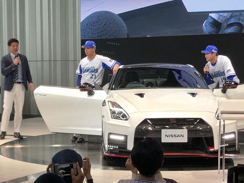 日産本社で開かれたトークショーに参加し、GT－Rに寄りかかり、ポーズを決めるDeNA今永（中央）と山崎