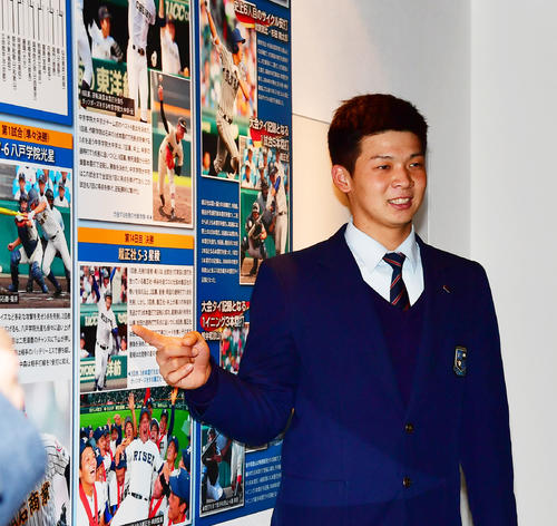 甲子園歴史館に展示されてある自身の写真を指さす井上広大（撮影・清水貴仁）